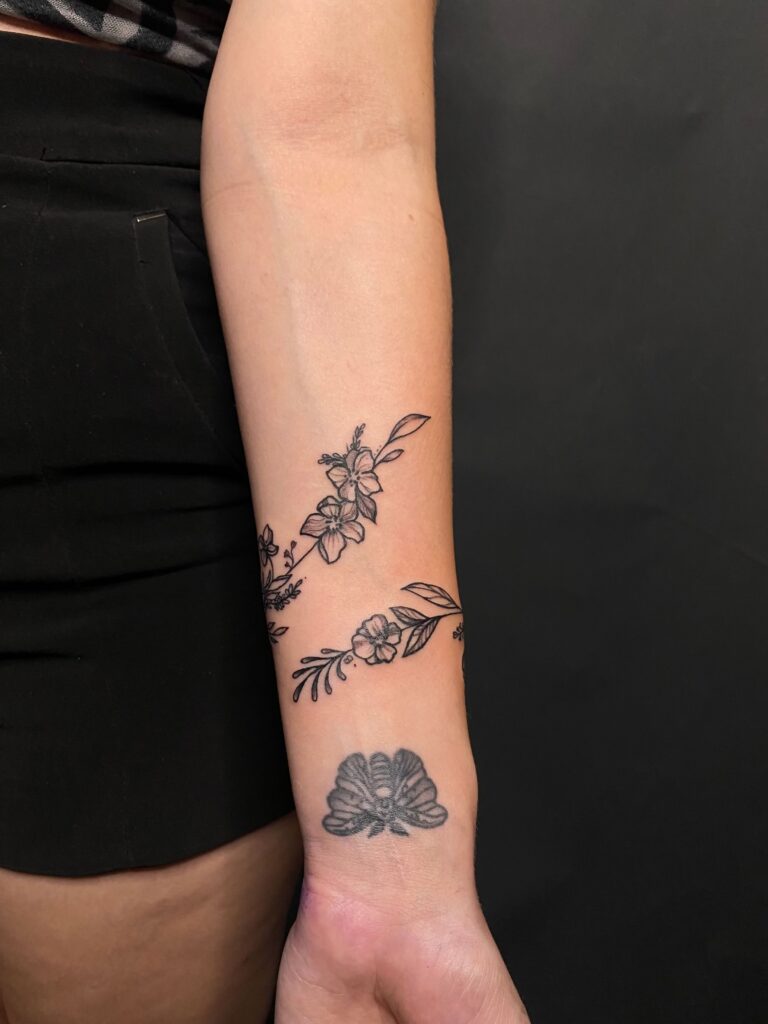tattoo tatuaj tatuat de berea ana maria pe o fata pe mana incheietura antebrat cu flori frunze floare de cires bratra de flori bracelet