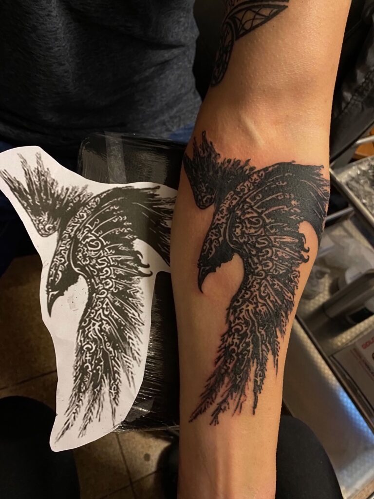 tattoo tatuaj tatuat de berea ana maria pe baiat boy in zona brat mana antebrat in stil blackwork cu o pasare cioara crow cu rune runes viking vikings