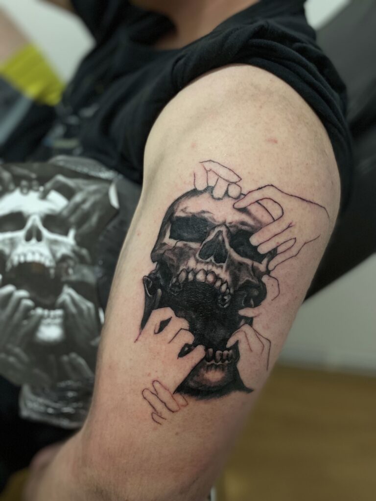 tattoo tatuaj tatuat de berea ana maria pe mana brat umar in stil realist blackwork cu craniu maini skull